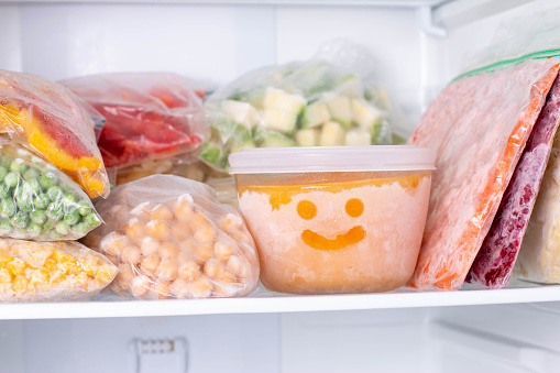 Comida congelada en el congelador. Verduras congeladas, sopa, comidas preparadas photo
