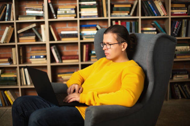 istock Man using laptop in library. Trendy colors of the year 1292300281