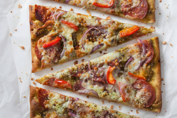 istock Basil Pesto Flat Bread Pizza with Cured Meats, Red Peppers and Spanish Onions 1292300380