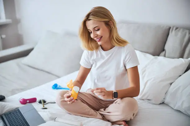 Photo of Happy smiling Caucasian female resting and relaxing while taking son care with beauty products