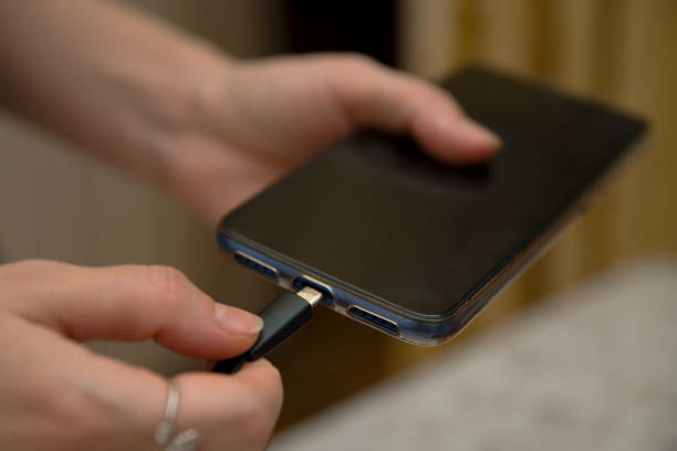 istock insert the adapter into the phone. female hands 1292301182