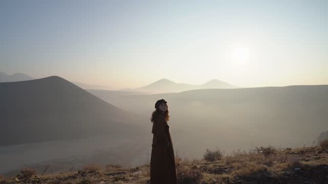 Woman standing and looking at volcano