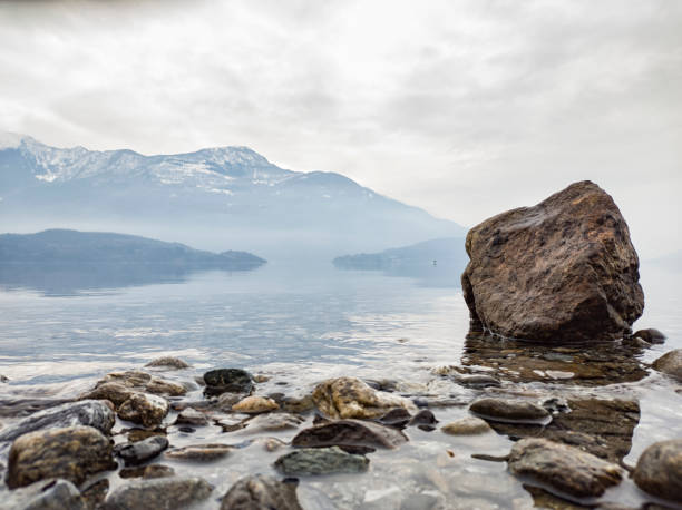 冬のコモ湖の湖畔の岩 - comune di lecco ストックフォトと画像