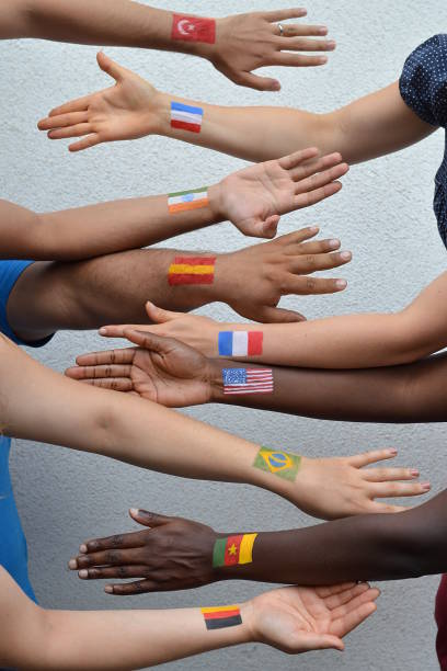 international people from different nations with flags on arms International brothers and sisters, men and woman from different nations with flags painted on their arms stretching out their hands to each other in peace german ethnicity stock pictures, royalty-free photos & images