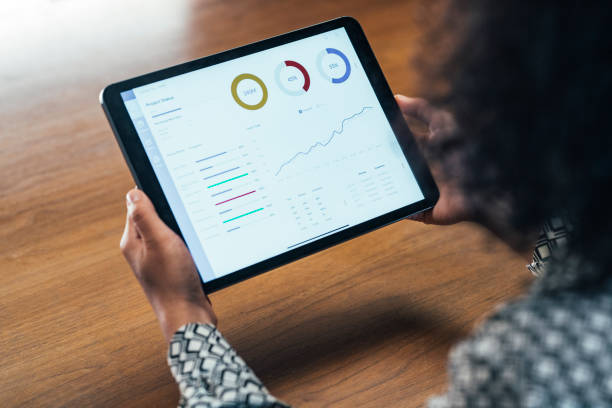istock Close Up: Anonymous Businesswoman Analyzing Statistical Business Reports on her Tablet PC at the Office 1292307463