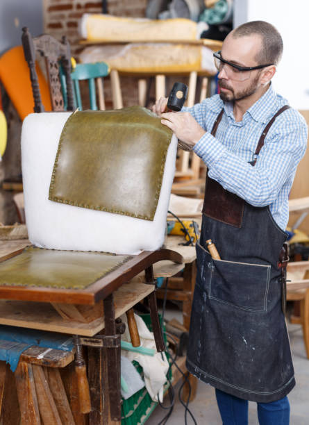istock Craftsman reupholstering chair in workshop 1292310792