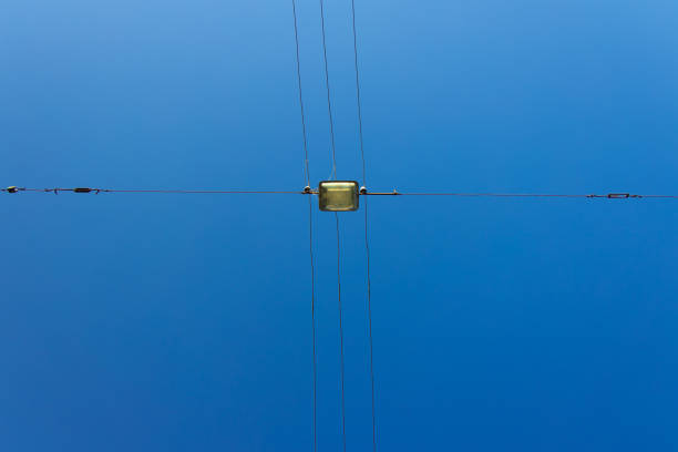 high voltage wires street infrastructure electricity object foreshortening from below with vivid blue sky background view in clear weather day time