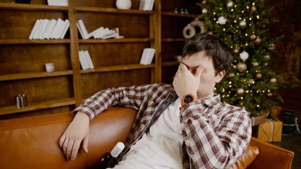 istock Alcohol addiction at young age. Caucasian male cannot stop drinking alcohol, drunken lonely male drinks wine from bottle. Loneliness, depression and alcoholism during Christmas and New Year holidays 1292314506