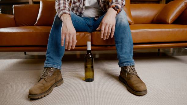 istock Alcohol addiction at young age. Caucasian male cannot stop drinking alcohol, drunken lonely male drinks wine from bottle. Loneliness, depression and alcoholism during Christmas and New Year holidays 1292315127