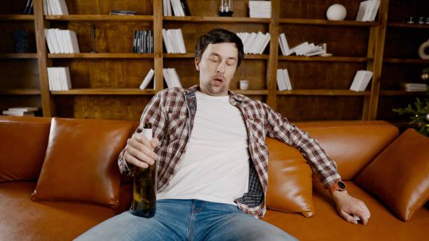 istock Alcohol addiction at young age. Caucasian male cannot stop drinking alcohol, drunken lonely male drinks wine from bottle. Loneliness, depression and alcoholism during Christmas and New Year holidays 1292315181