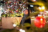 クリスマスライトを楽しむために仕事の後に街を訪れる若い女性