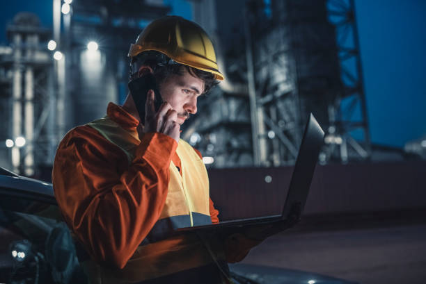 istock Engineer working late nightshift with laptop and talking on the phone. 1292315362