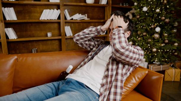 istock Alcohol addiction at young age. Caucasian male cannot stop drinking alcohol, drunken lonely male drinks wine from bottle. Loneliness, depression and alcoholism during Christmas and New Year holidays 1292315445