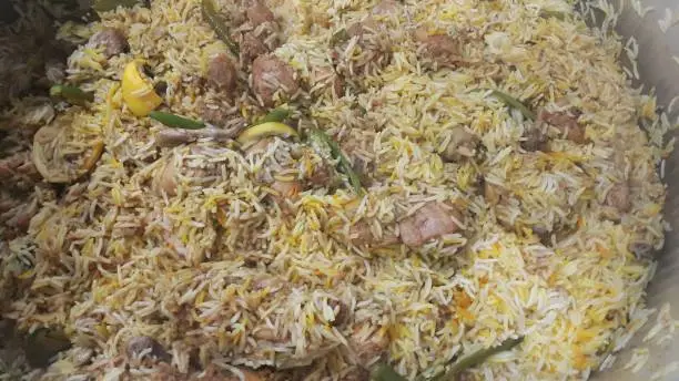 A close up  view of cooked rice chicken biryani made with traditional recipe popular for its delicious taste in Pakistan