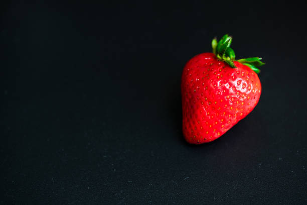 istock Close up of fresh strawberries on black background 1292317877