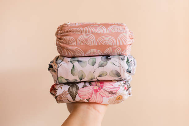 istock A Woman Holding a Stack of Modern Neutral-Colored Reusable Cloth Diapers with a Neutral Background in Bright Natural Light 1292319551