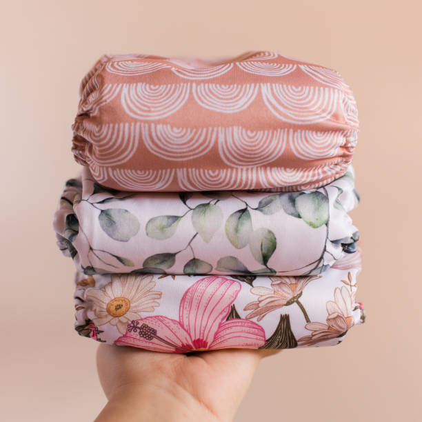 istock A Woman Holding a Stack of Modern Neutral-Colored Reusable Cloth Diapers with a Neutral Background in Bright Natural Light 1292320491