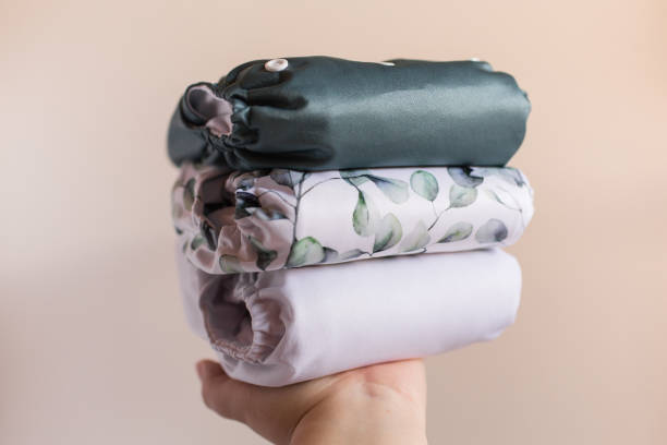 istock A Woman Holding a Stack of Modern Neutral-Colored Reusable Cloth Diapers with a Neutral Background in Bright Natural Light 1292320703