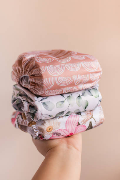 istock A Woman Holding a Stack of Modern Neutral-Colored Reusable Cloth Diapers with a Neutral Background in Bright Natural Light 1292320735