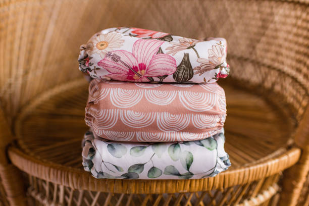 A Girly Stack of Modern & Colorful Reusable Cloth Diapers with a Neutral Background in Bright Natural Light