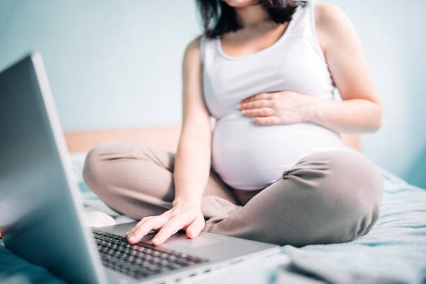 istock Pregnant woman using laptop at home 1292322627