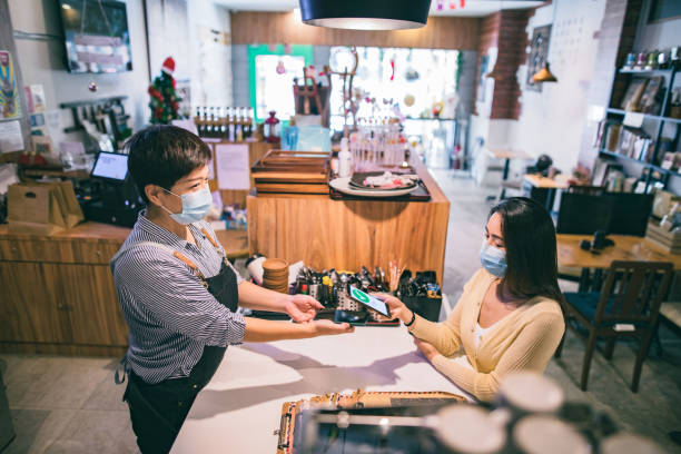 istock Asian girl with face mask pay at cafe 1292331963