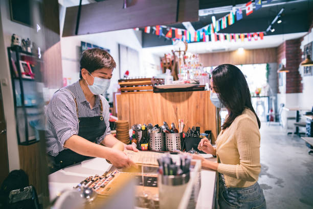 istock Asian girl with face mask pay at cafe 1292332014