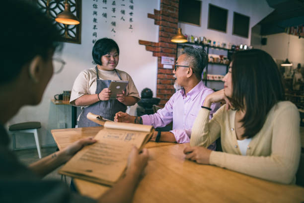 istock Asian disable cafe worker taking and delivering order in cafe 1292332591