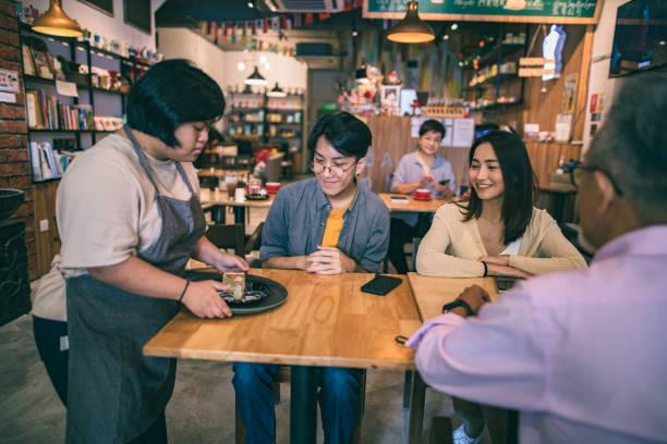 istock Asian disable cafe worker taking and delivering order in cafe 1292333382