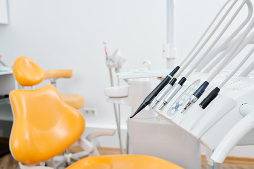 Chair and equipment and tools in modern dental clinic, oral care and healthcare concept