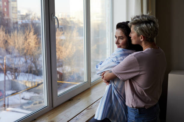 istock Lesbian couple hugging near window 1292337478