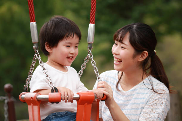 istock Parents and children playing on a swing 1292340129