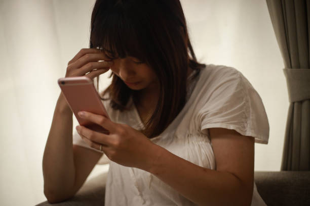 istock A woman holding her head looking at a smartphone 1292341966