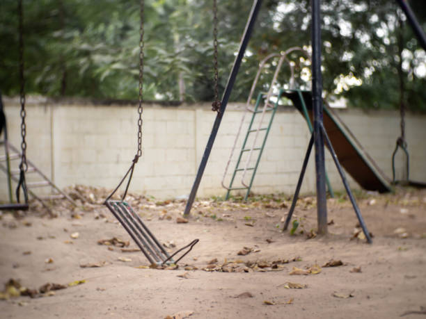 одна сторона сломанного железа качели - swing playground empty abandoned стоковые фото и изображения