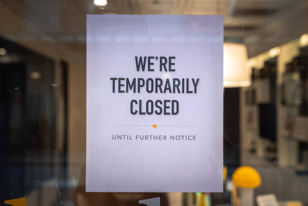 A printed sign is taped to a storefront business in downtown Chicago indicating the business is temporarily closed due to Covid-19 coronavirus pandemic. stock photo