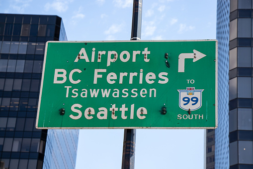 Vancouver, Canada - June 29,2020: View of the road sign with directional arrow points to Airport, Tsawwassen, Seattle in downtown Vancouver