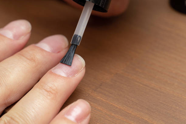 istock Applying primer, colorless nail polish with brush on finger 1292352820