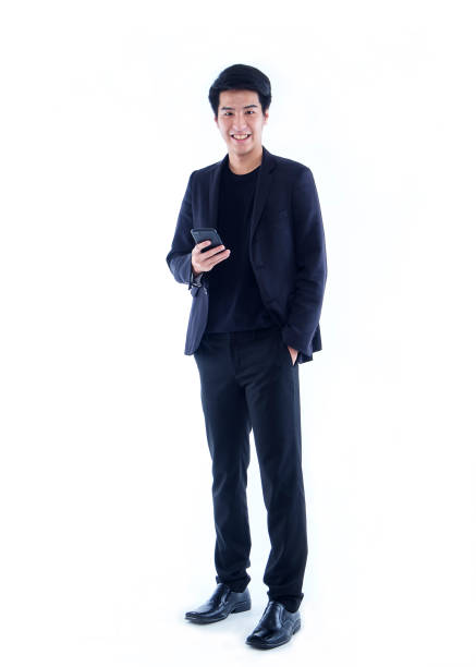 молодой человек со смартфоном на белом фоне - asian ethnicity suit business men стоковые фото и изображения