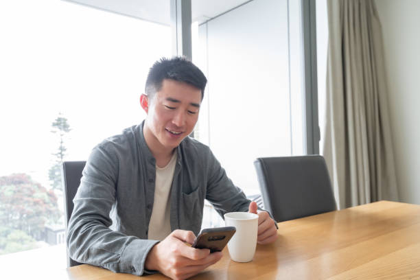 istock Young Asian man using phone with a positive facial expression using phone 1292357858