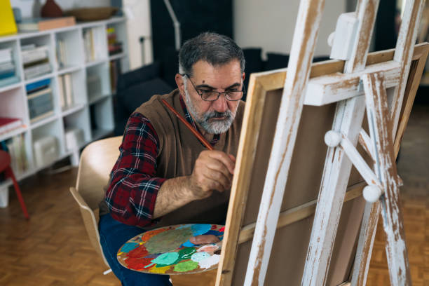 istock senior man relaxing at home and painting 1292358312