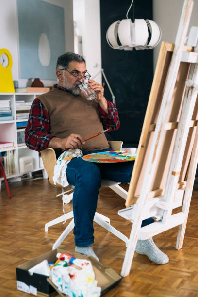 istock senior man relaxing at home and painting 1292358363