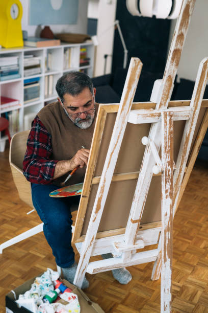 istock senior man relaxing at home and painting 1292359014