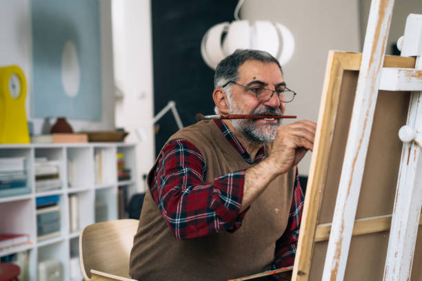 istock senior man relaxing at home and painting 1292359081