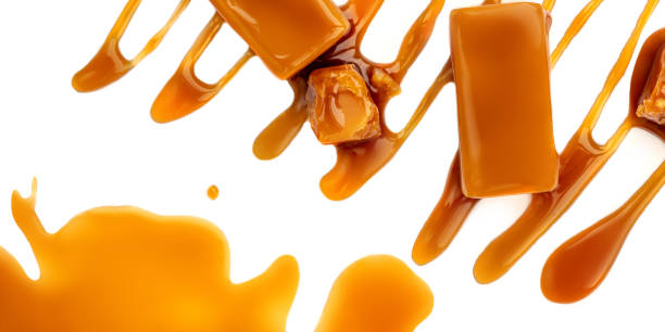 istock Sweet Caramel candies and syrup topping isolated on a white background. Creative layout made of caramel  closeup. Flat lay. Food concept.