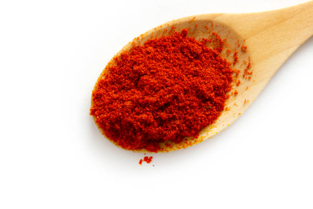 Paprika powder in wooden spoon Paprika powder in wooden spoon cayenne powder stock pictures, royalty-free photos & images