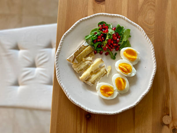 istock Healthy Homemade Breakfast Plate with Moldy Cheese, Boiled Eggs, Rucola Arugula or Rocket Leaves with Pomegranate Seeds on Wooden Table. 1292364802