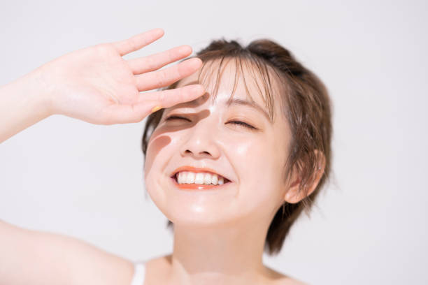 明るい日光を遮る若いアジアの女性 - bright skin ストックフォトと画像