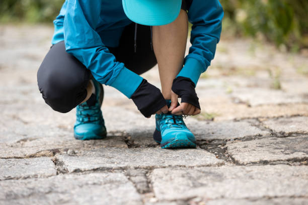 istock Woman runner tying shoelace on trail 1292365498