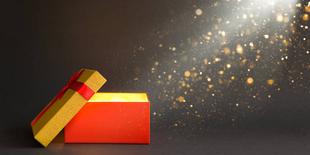 istock Open red gift box with a bow with a golden glow and glitter inside on a black background, banner, copyspace. universal holiday, christmas, valentine's day, new year, birthday, black friday 1292365619