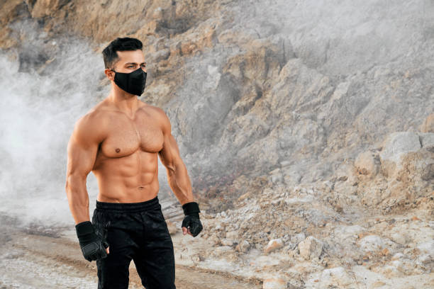 istock Athletic man in mask showing his muscular body on camera 1292365741